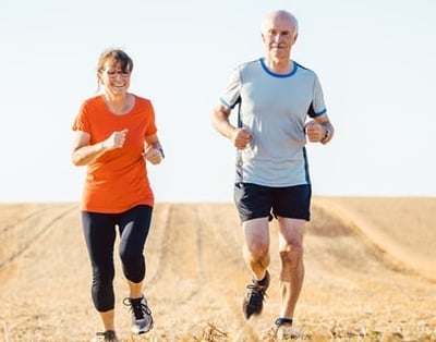 Senioren Frau und Mann joggen auf einem Feld