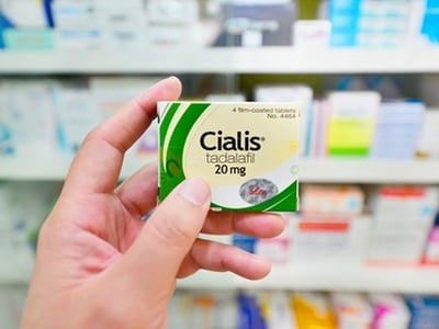 Ein Mann mit einer Packung Cialis in einer Apotheke