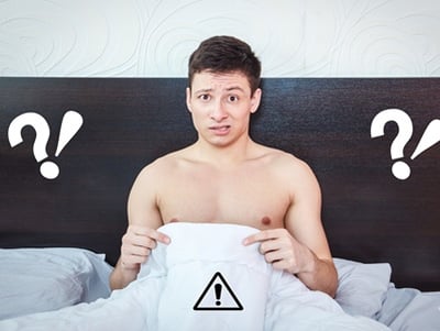 Ein junger Mann, der über seine sexuellen Probleme im Bett nachdenkt