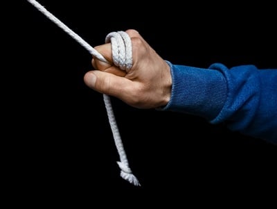 Die Hand eines Mannes, die sich an einem Seil festhält
