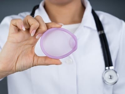 Eine Ärztin hält ein Diaphragma zur Empfängnisverhütung in der Hand