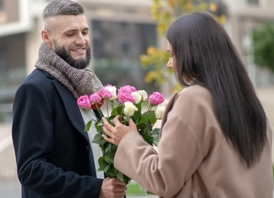 Ein Mann schenkt einer Dame Blumen