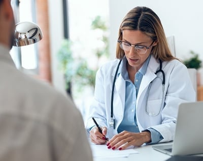 A woman doctor prescribing medication to a man