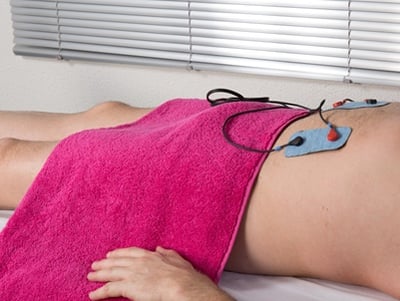Ein Mann nimmt eine Massage mit Elektrostimulator vor, um die Potenz zu steigern