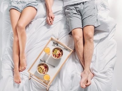 Um casal a tomar o pequeno-almoço na cama