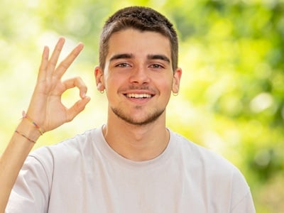 Ein positiver junger Mann mit ok-Zeichen
