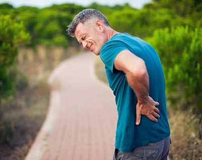 Mann mit Rückenschmerzen im Freien