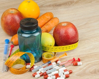 Früchte und Abnehmmedikamente mit Messband