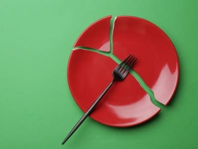Eine Gabel und ein zerbrochener roter Teller