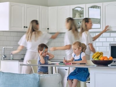 Viel beschäftigte Mutter, die ihre Kinder füttert und das Haus putzt
