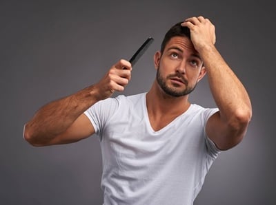 Ein gutaussehender Mann, der sich stilvoll die Haare kämmt