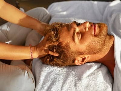 Ein Mann genießt eine Kopfhautmassage im Spa