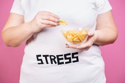 Ein Mädchen isst Fast Food, weil sie gestresst ist