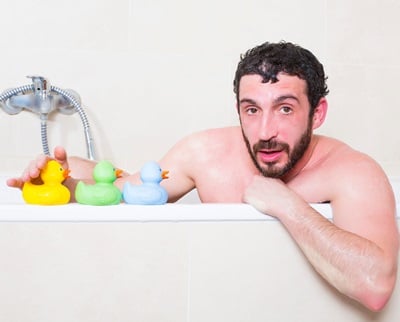  Ein Mann nimmt ein Bad mit drei Gummienten