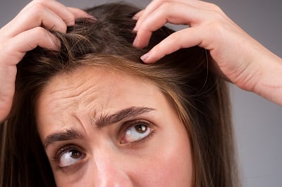 Eine gestresste Frau ist wegen ihres Haarausfalls sehr aufgebracht.
