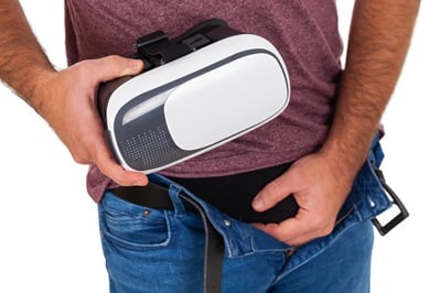 Ein Mann hält seinen Penis und ein VR-Headset