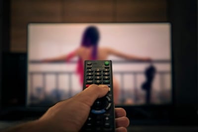 Ein Mann sieht sich einen Porno im Fernsehen an