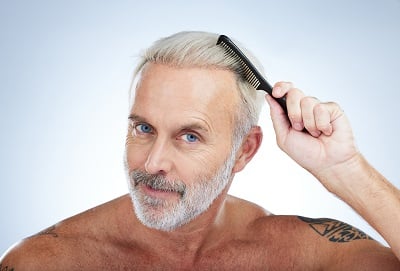 Ein Mann begutachtet die Ergebnisse der Mesotherapie gegen Haarausfall.