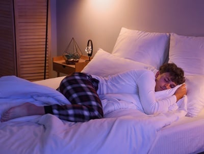 Ein Teenager, der nachts im Bett schläft