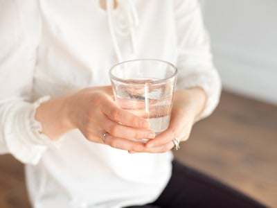 Eine Frau hält ein Glas Wasser