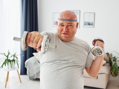Ein übergewichtiger Mann, der zu Hause Sport treibt.