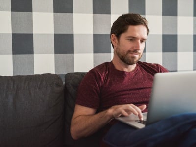 Ein Mann mit einem Laptop beim Surfen