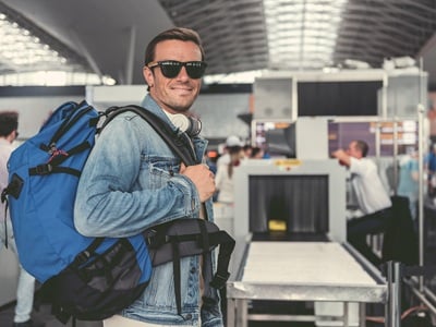 Ein positiver erwachsener Mann geht auf Reisen.