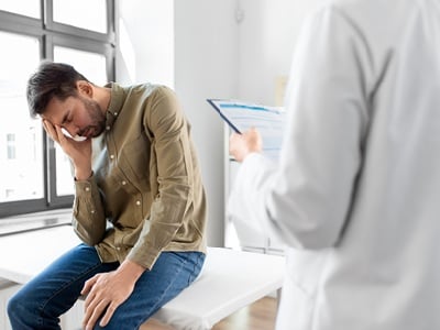 Ein Arzt und trauriger Mann mit Gesundheitsproblemen im Krankenhaus