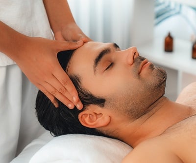 Ein Mann genießt eine Kopfmassage und verwöhnt die Gesundheit seiner Haare.