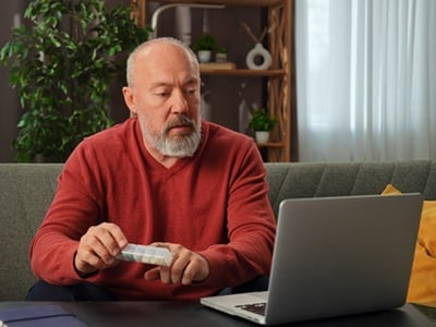 Ein &auml;lterer Mann, der Medikamentenbewertungen im Internet &uuml;berpr&uuml;ft.