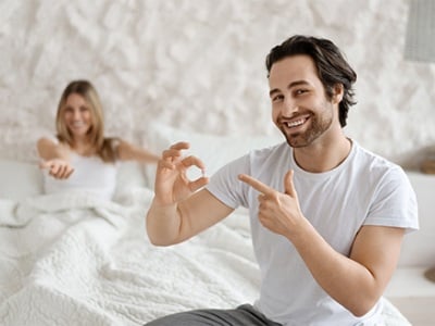 Ein Mann ist zufrieden mit seinem Potenzmittel, das er vor dem Sex eingenommen hat