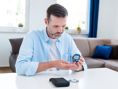 Ein Mann mit Diabetes misst den Blutzucker