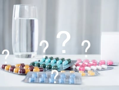 Verschiedene ED-Medikamente mit einem Glas Wasser