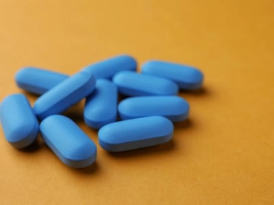 Blaue Tabletten auf einem orangefarbenen Hintergrund