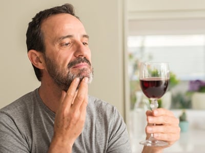 Ein Mann überlegt, Wein zu trinken.