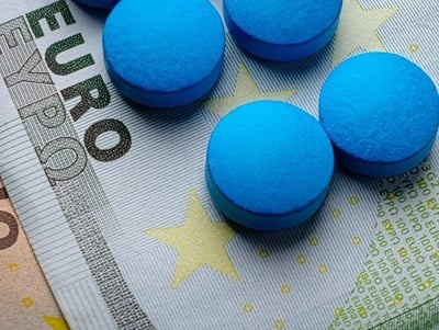 Blaue Pillen auf einem 100-Euro-Schein