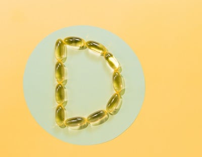 Vitamin-D3-Gelkapseln auf gelbem Hintergrund