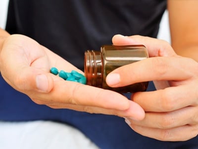 Ein Mann nimmt blaue homöopathische Pillen