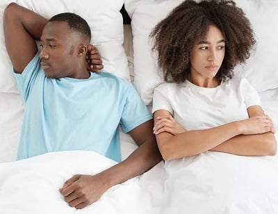 Ein Paar im Bett ist frustriert wegen der sexuellen Probleme des Mannes.
