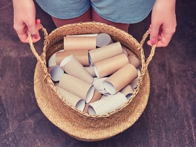 Eine Frau hält eine Menge leerer Toilettenpapierrollen