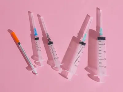 Spritzen für Gewichtsabnahme auf rosa Hintergrund