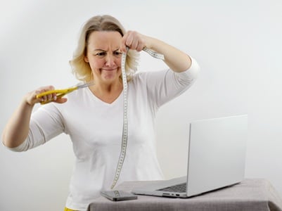 Eine Frau kämpft mit einem Maßband und einer Schere, während sie versucht, Gewicht zu verlieren.