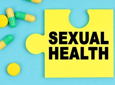 Pillen und ein Puzzle mit der Aufschrift - SEXUAL HEALTH