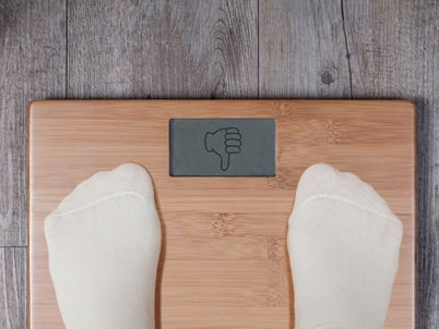 Daumen-runter-Geste auf der Waage