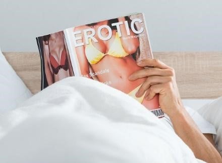 Um homem a ler uma revista erótica