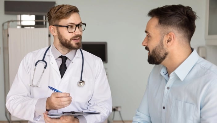 Médico conversa com paciente durante consulta