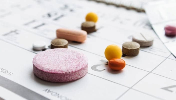 Pills and supplements placed on a weekly medication schedule