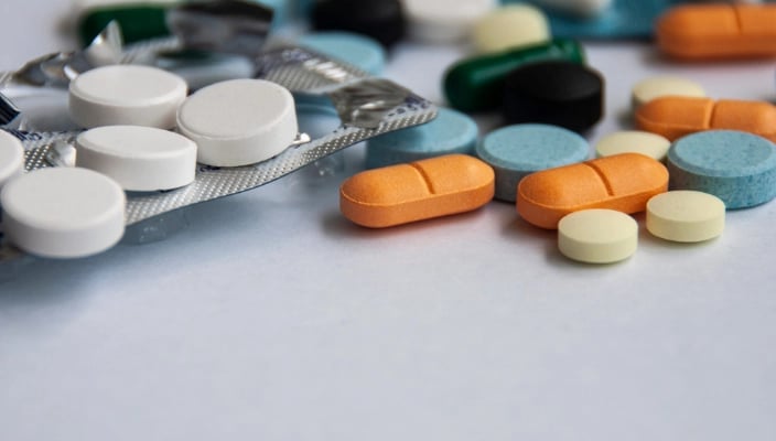 Verschiedene Tabletten und Kapseln auf weißem Hintergrund