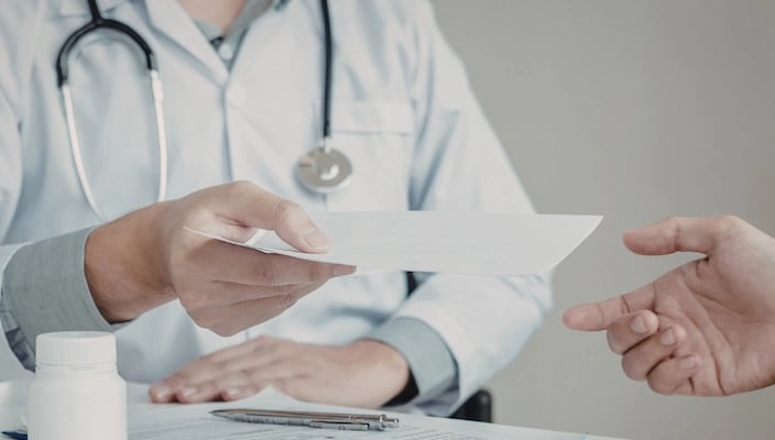 En läkare ger ett recept till en patient