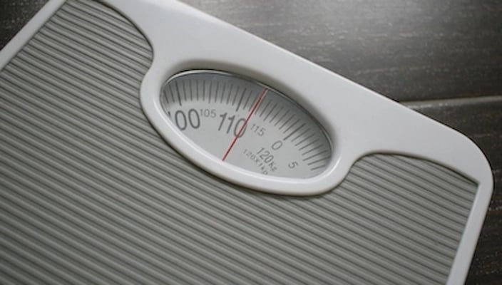 Analoge Personenwaage mit Anzeige von etwa 112 kg